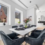 Essbereich mit Tisch und Stühlen, Blick auf Straße und Haus.