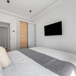 Schlafzimmer mit Bett, Fernseher und Kleiderschrank