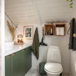 Badezimmer mit Toilette, Waschbecken und Aufbewahrungskörben an der Wand.