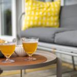 Auf dem Balkon stehen zwei Gläser mit Getränk und eine Schale mit Chips.