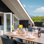 Terrasse mit gedecktem Tisch, Sitzgelegenheiten und Blick auf grüne Landschaft.