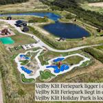 Vejlby Klit Feriepark mit Minigolf, Teichen und Spielbereichen in grüner Landschaft.
