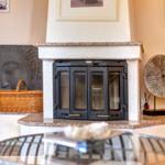 Kamin mit Steinsockel, dekorative Wandobjekte und Korb auf Sockel