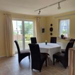 Esszimmer mit Tisch, sechs Stühlen und Blick auf Garten.