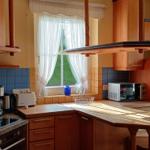 Küche mit Holzmöbeln, Fenster und Mikrowelle