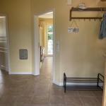 Flur mit Garderobe, Stuhl und Blick in Wohn- und Essbereich.