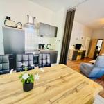 Küche mit Essbereich und Wohnzimmer mit Bett und Sessel