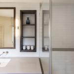 Badezimmer mit Dusche, Waschbecken und Spiegel