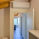 Raum mit Holzdecke, Klimaanlage und Blick auf Balkon.