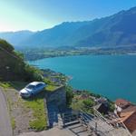 Auto parkt an Straßenrand mit Blick auf See und Berge.