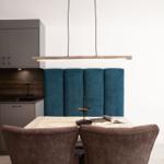 Essbereich mit Holztisch, blauer Sitzbank und moderner Küchenzeile.