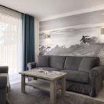 Wohnzimmer mit Sofa, Couchtisch und Wandbild von Surfer.