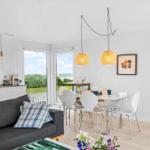 Wohn- und Essbereich mit Küchenzeile, Tisch, Stühlen und Blick auf die Landschaft.