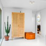 Eingangsbereich mit Kleiderschrank, Pflanze und Sitzkissen. Durchgang zur Toilette.