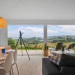 Wohn- und Essbereich mit Blick auf Garten und Landschaft.