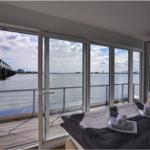 Schlafzimmer mit Blick auf Wasser und Steg. Bett mit Handtüchern.