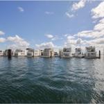 Wohnungen auf Wasser mit Blick auf Himmel und See.