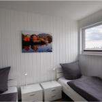 Zwei Einzelbetten mit Nachttischen und Fensterblick auf einen Turm.