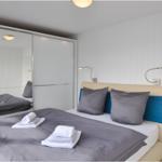 Schlafzimmer mit Bett, Kleiderschrank und Nachttisch