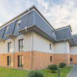 Moderne zweistöckige Villa mit Ziegelfassade und Dachgauben.