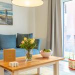 Ein Wohnzimmer mit blauem Sofa, Holztisch und Spielzeug.