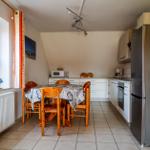 Moderne Küche mit großer Gefrier-Kühlschrankkombination,
Backofen , Mikrowelle, Kaffemaschine und Wasserkocher.
großer Esstisch.