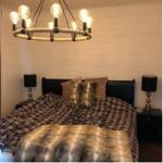 Schlafzimmer mit Bett, Nachttischen und Kronleuchter.