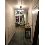 Flur mit Holzwand, Steinboden und Weihnachtsbaum im Hintergrund