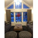 Wohnzimmer mit zwei Sofas, Holztisch und roter Sterndekoration an der Wand.