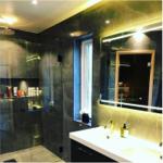 Bad mit Dusche, Waschbecken und Spiegel