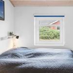 Schlafzimmer mit Bett, Fenster und Wandbild.