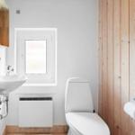 Badezimmer mit Toilette, Waschbecken und Fenster.