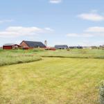 Grüner Rasenplatz mit Blick auf mehrere Häuser im Hintergrund.