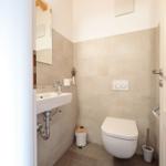 Badezimmer mit Waschbecken, Spiegel und WC.