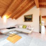 Wohnzimmer mit Sofa, Glas-Tisch und Holzdecke