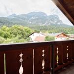 Balkon mit Holzgeländer bietet Blick auf Berge und Dörfer.