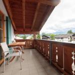 Terrasse mit Tisch, Stühlen und Blick auf Berglandschaft.