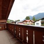 Terrasse mit Holzgeländer und Blick auf Berge und Häuser