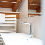 Waschbecken mit Wasserhahn und Handtuchhalter unter Holzdecke