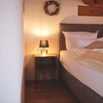 Schlafzimmer mit Bett, Nachttisch und Lampe. Wanddekoration und Holzkonstruktion.