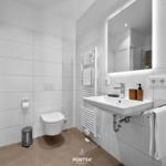 Badezimmer mit Toilette, Waschbecken und Spiegel