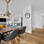 Essbereich mit Tisch, Stühlen und Obst. Küche, Wohnzimmer und Bad sind sichtbar.