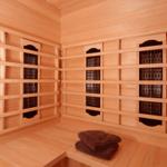 Sauna mit Holzbank und dunklen Handtüchern an der Wand.