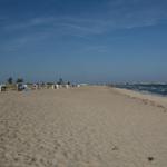 Strand mit Strandkörben und Meer unter blauem Himmel