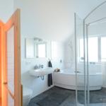 Badezimmer mit Sauna, Badewanne und Dusche.