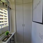 Schlafzimmer mit Kleiderschrank, Fenster und Bild an der Wand.