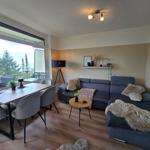 Wohn- und Essbereich mit Balkonblick. Sofa, Tisch und Stühle.