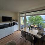 Wohnküche mit Essbereich und Balkonblick aufs Meer.