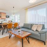 Wohnküche mit Sofa, Esstisch und Kücheneinrichtung.