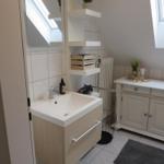 Badezimmer mit Waschbecken, Spiegelschrank und Fenster